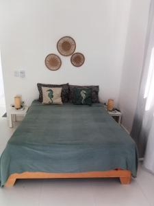 a bedroom with a large green bed with two tables at villa caraibica piscina privata in Sosúa