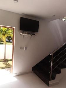 a flat screen tv on a wall next to a staircase at villa caraibica piscina privata in Sosúa