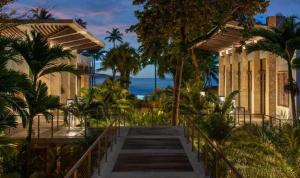 a staircase leading to a building with palm trees at Villa Granada at Dorado Beach Resort pool nearby in Dorado