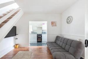 a living room with a couch and a staircase at Cheerful Maisonette in the heart of Orrell Park in Liverpool