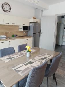 a kitchen with a table with chairs and a clock at Apartament regim hotelier Băile Felix in Baile Felix