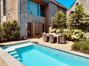 a swimming pool in a yard with a table and chairs at A Upendi in Clavier