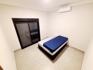 a bedroom with a bed with a blue mattress at Linda casa a 200m da Praia do Capricórnio in Massaguassu