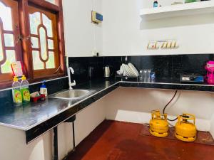 a kitchen with a sink and two yellow appliances at Rustic Inn in Mirissa +28 photos