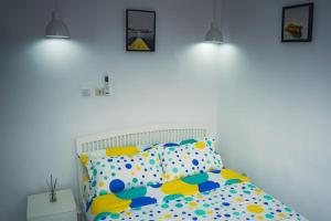 een witte slaapkamer met een bed met kussens met stippen bij Appartement 2pièces et terrasse in Abidjan