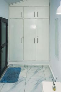 een kamer met witte kasten en een blauw vloerkleed bij Appartement 2pièces et terrasse in Abidjan