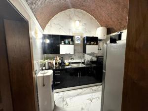 a kitchen with black and white counter tops and a refrigerator at 1-Bedroom Guesthouse in Giza +8 photos