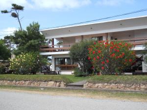 Un edificio con flores rojas en el frente. en Hotel Yeruti, en La Paloma