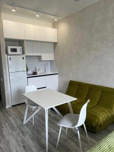 a kitchen and a living room with a white table and chairs at Snowy Pines Gudauri Alpic Ski Resort in Gudauri