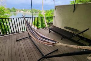 a hammock on a deck with a view of a river at Louis Chalet - tranquil hideout in Moratuwa