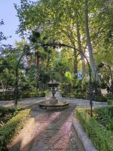 una fuente en medio de un parque con árboles en El Capricho, en Ronda 28 fotos más