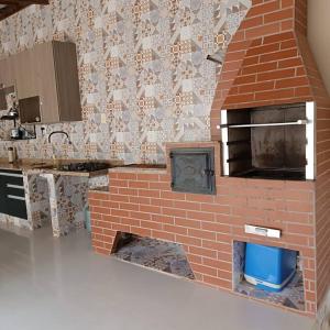 a kitchen with a brick oven in a kitchen at Casa em São Thomé das Letras in São Thomé das Letras