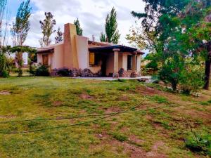 a house with a hose in front of a yard at Casa en potrerillos in Potrerillos