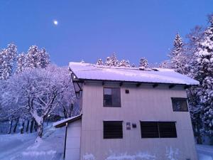 a house with snow on the top of it at Yuki Lodge Myoko in Myoko +11 photos