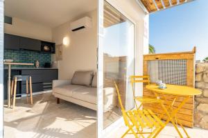 a living room with a yellow table and a couch at Cozy Ocean View Cala Crancs Flat in Salou