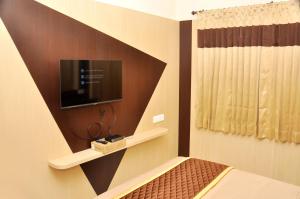 a bedroom with a bed and a tv on a wall at Harikrishna Park in Coimbatore