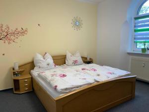 a bedroom with a bed with pink flowers on it at Ferienwohnung Bad Kösen in Bad Kösen