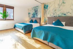 two beds in a room with blue and white at LiT LiVING - Luxury Penthouse - Box Spring in Weinheim