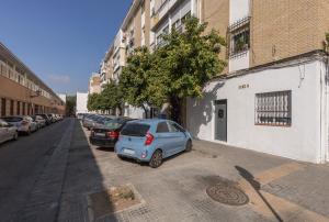 un pequeño coche azul estacionado al lado de una calle en Justino Triana Central by Valcambre, en Sevilla