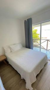 een wit bed in een kamer met een raam bij Casa Mar in Puerto Colombia +24 foto's