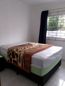 a bed in a room with a tiger blanket on it at Casa F Pontal do Paraná in Pontal do Paraná