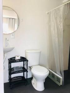 a bathroom with a toilet and a sink and a mirror at Pousada LUGAR - Quarto MAR familiar e tranquilo in Penha