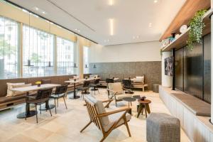 a restaurant with tables and chairs and windows at Citadines Kurfürstendamm Berlin in Berlin