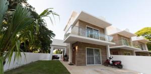 a house with a scooter parked in front of it at Tropical Paradise Villa in Sosua in Sosúa