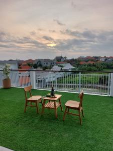 un patio con 2 sillas y una mesa en el césped en Omah Santai Canggu, en Canggu 9 fotos más