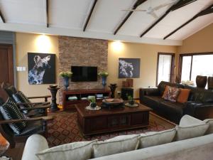 a living room with couches and a tv at Thornwood in Hluhluwe