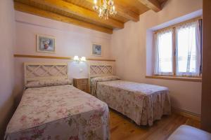 una camera da letto con due letti e un lampadario di Casa Rural Villa de San Leonardo a San Leonardo de Yagüe