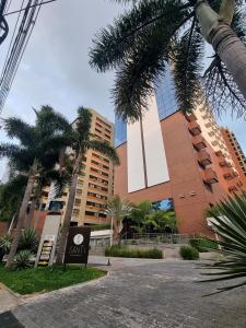 a building with palm trees in front of it at AlphaStay by Rhouses in Barueri