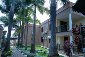 a building with palm trees in front of it at The Country Inn Hotel in Kigali