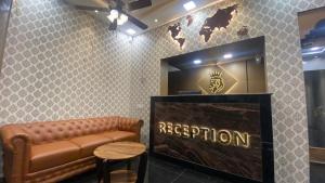 a waiting room with a brown leather couch and a sign at Esakki Empire in Chennai