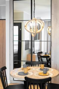 a dining room table with chairs and a chandelier at Perfect Stay - "Apartament Cosmo" - free parking in Toruń