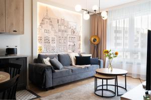 a living room with a blue couch and a table at Perfect Stay - "Apartament Cosmo" - free parking in Toruń