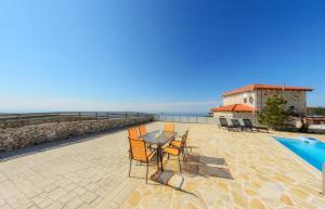 un patio avec une table et des chaises à côté d'une piscine dans l'établissement Sunset Vista Villas Classic II, à Volímai