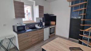 a small kitchen with a sink and a microwave at Chez Martin - centre-ville in Brassac-les-Mines