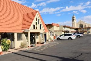 a building with an orange roof next to a parking lot at Super 8 by Wyndham Albuquerque Downtown in Albuquerque