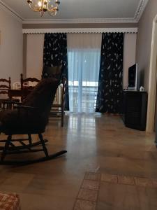 a living room with a rocking chair and a table at FLAT with Private Rooms in Agrinion