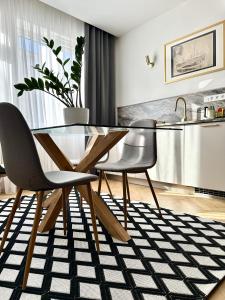 ein Esszimmer mit einem Glastisch und 2 Stühlen in der Unterkunft KIKI stay and art in Košice