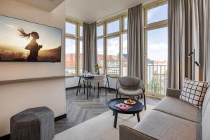 a living room with a couch and a table at Citadines Kurfürstendamm Berlin in Berlin