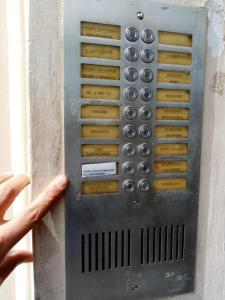 a man is pointing at a metal wall with buttons at Hostel Castello Maggiore in Rome