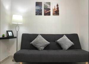 1 sofá gris con 2 almohadas en la sala de estar en Hermosa casa céntrica en Playa del Carmen, en Playa del Carmen