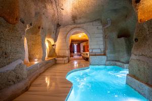 a swimming pool in a cave with a stone wall at Gamirasu Village House in Nevsehir
