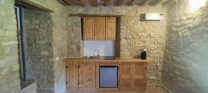 a kitchen with a sink and a stone wall at Guesthouse Nicol 2 in Collelungo