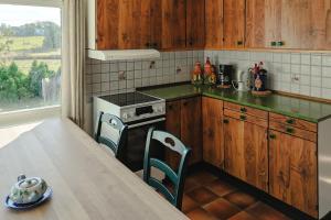 a kitchen with wooden cabinets and a table with a table sidx sidx at Det huset på landet in Nøtterøy