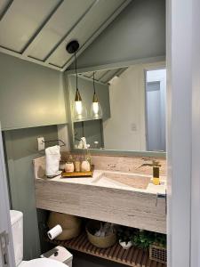 a bathroom with a sink and a large mirror at Residência Exclusiva no Condomínio Blue, Xangri-Lá in Xangri-lá