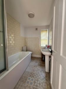 a white bathroom with a tub and a sink at Rubber Chicken House - Ramsgate in Ramsgate +22 photos