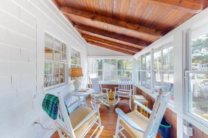 een kamer met stoelen, een tafel en ramen bij Old Wharf Escape in Dennis Port